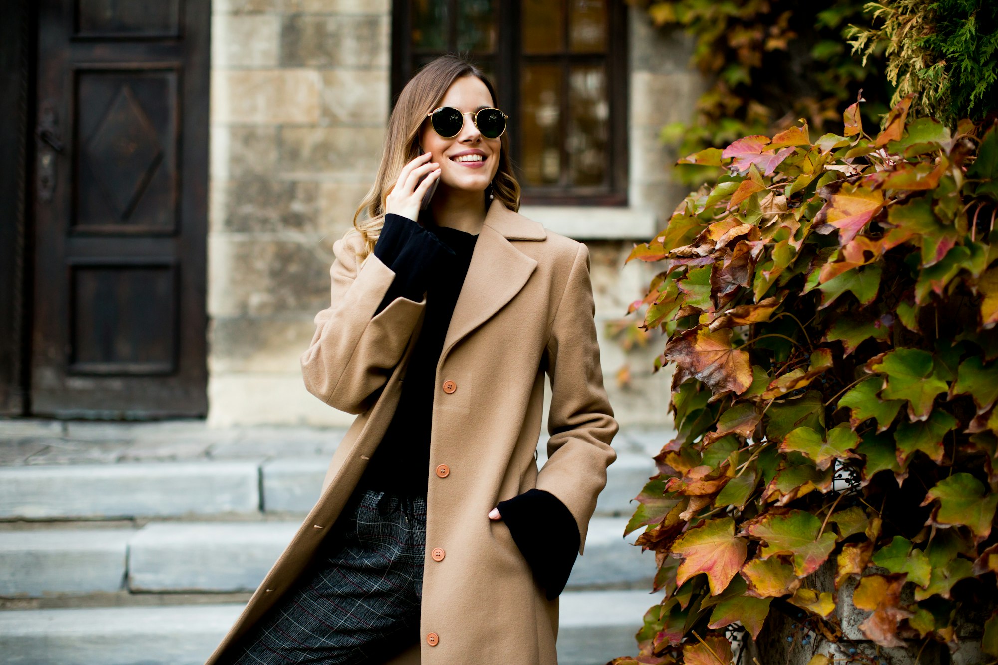 Modern woman using mobile phone at autumn outdoor